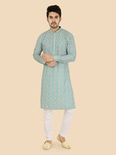 Man wearing a green patterned kurta with white pants