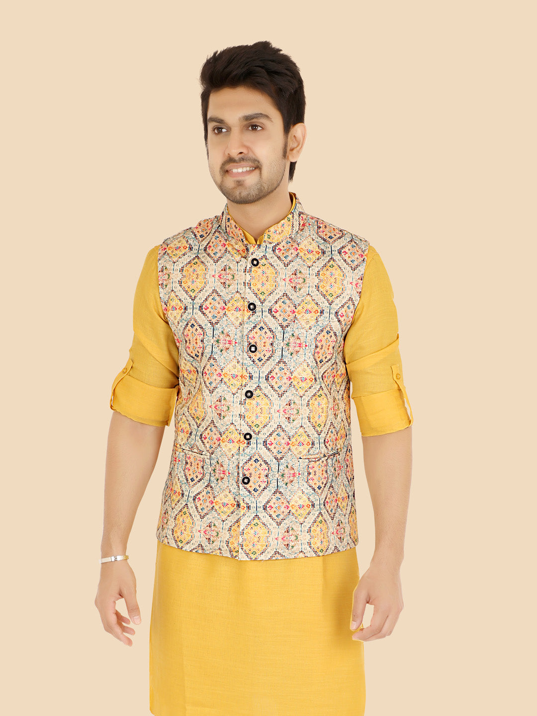 Man wearing a gold kurta with a patterned waistcoat 